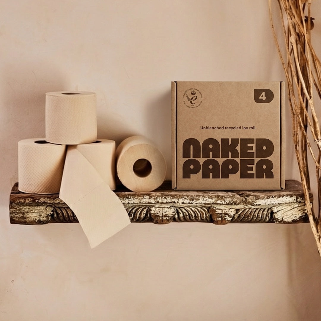 Trial box of Naked Paper on a bathroom shelf. Four rolls of Naked Paper toilet roll sit next to the box.